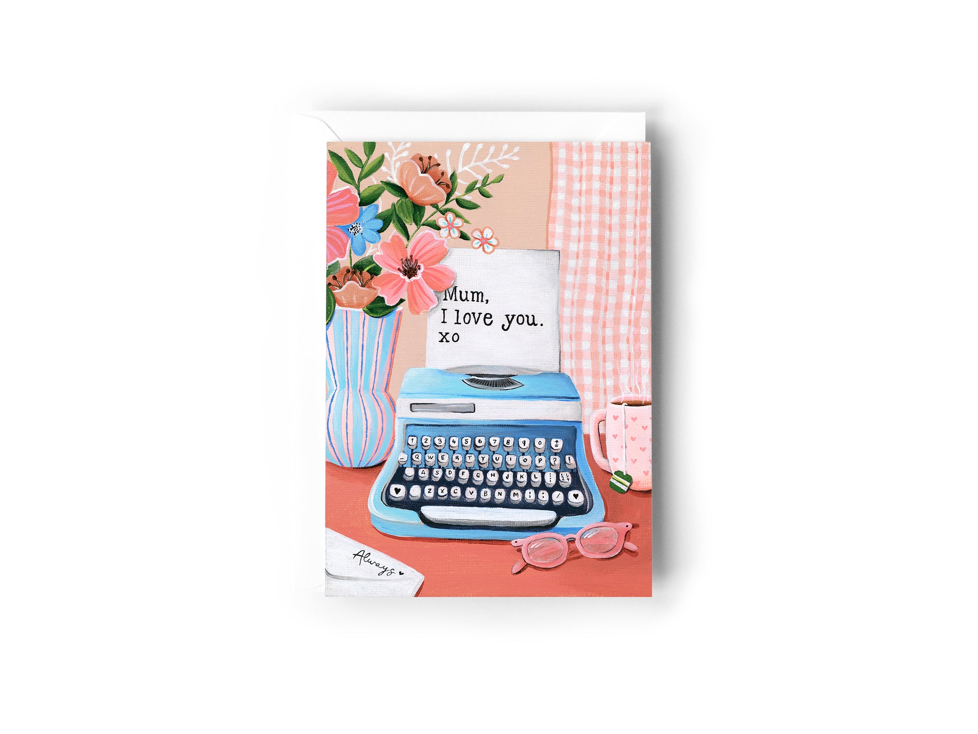 A greeting card featuring a retro illustration of a blue typewriter with a handwritten note that says 'Mum, I love you. xo', set against a pink and peach background with flowers, a mug, and pink glasses, by Australian Artist Jessica Alpert. The card has a white envelope behind it and sits on a white background.