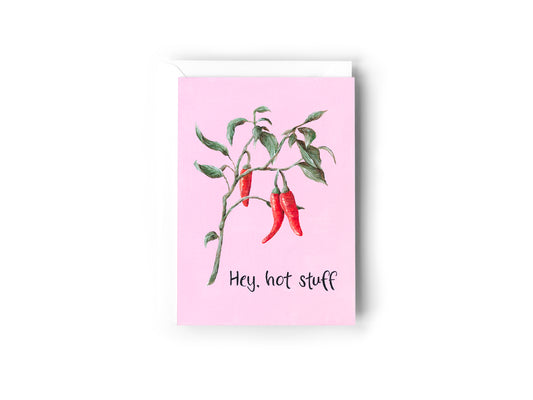 A greeting card design hand painted by Australian Artist Jessica Alpert featuring a chilli plant illustration on a pink background with the words 'Hey, hot stuff'. The card has a white envelope behind it and sits on a white background.