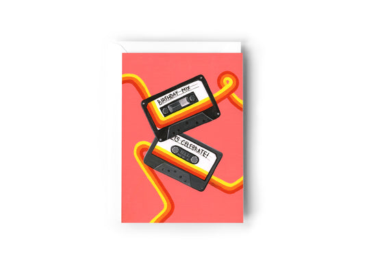 A Birthday Card design hand painted by Australian Artist Jessica Alpert of two casette tapes with 'Birthday Mix' and 'Lets celebrate' written on the two tapes. A retro red, orange and yellow line extends and curves around the card and across the tapes. The background is a vibrant soft red. The card has a white envelope behind it and sits on a white background.
