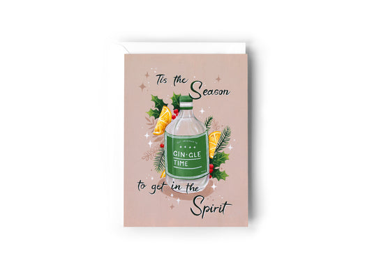 A Christmas Card design hand painted by Australian Artist Jessica Alpert. A green labelled bottle of gin sits centrally with holly, mistletoe, lemon slices, Christmas foliage and stars surrounding it. The Gin label says 'GIN-GLE TIME'. The words 'Tis The Season To Get In The Spirit' are written across the card. A taupe colour background covers the design. The card has a white envelope behind it and sits on a white background.