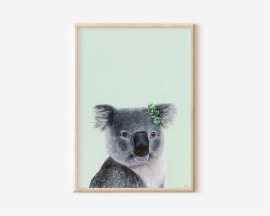 A Fine Art Print hand painted by Australian Artist Jessica Alpert of a detailed fluffy koala smiling with a leaf crown on it's right ear, sitting against a soft green background.