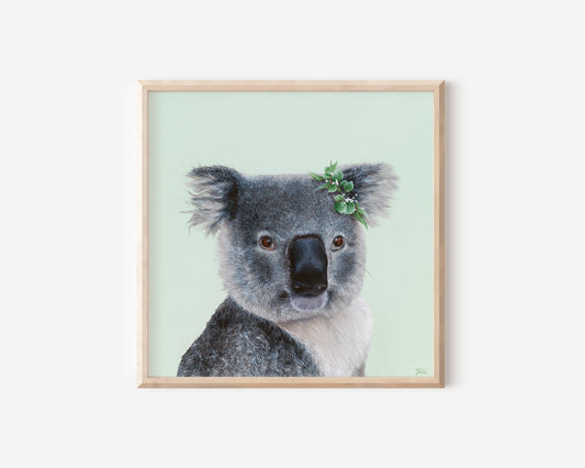 A Fine Art Print hand painted by Australian Artist Jessica Alpert of a detailed fluffy koala smiling with a leaf crown on it's right ear, sitting against a soft green background.