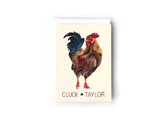 A greeting card design hand painted by Australian Artist Jessica Alpert of a rooster wearing red converse shoes on a cream background. The words 'Cluck Taylor' are written below the rooster. The card has a white envelope behind it and sits on a white background.