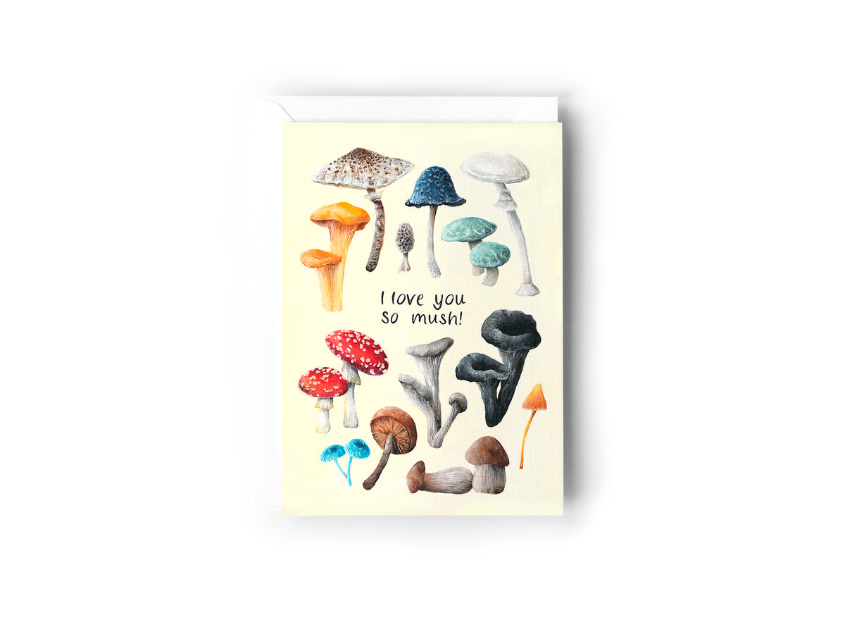 A greeting card design hand painted by Australian Artist Jessica Alpert featuring illustrations of different varieties of colourful mushrooms on a cream background. The words, 'I Love You So Mush!'' are written in black in the centre of the card. The card has a white envelope behind it and sits on a white background.
