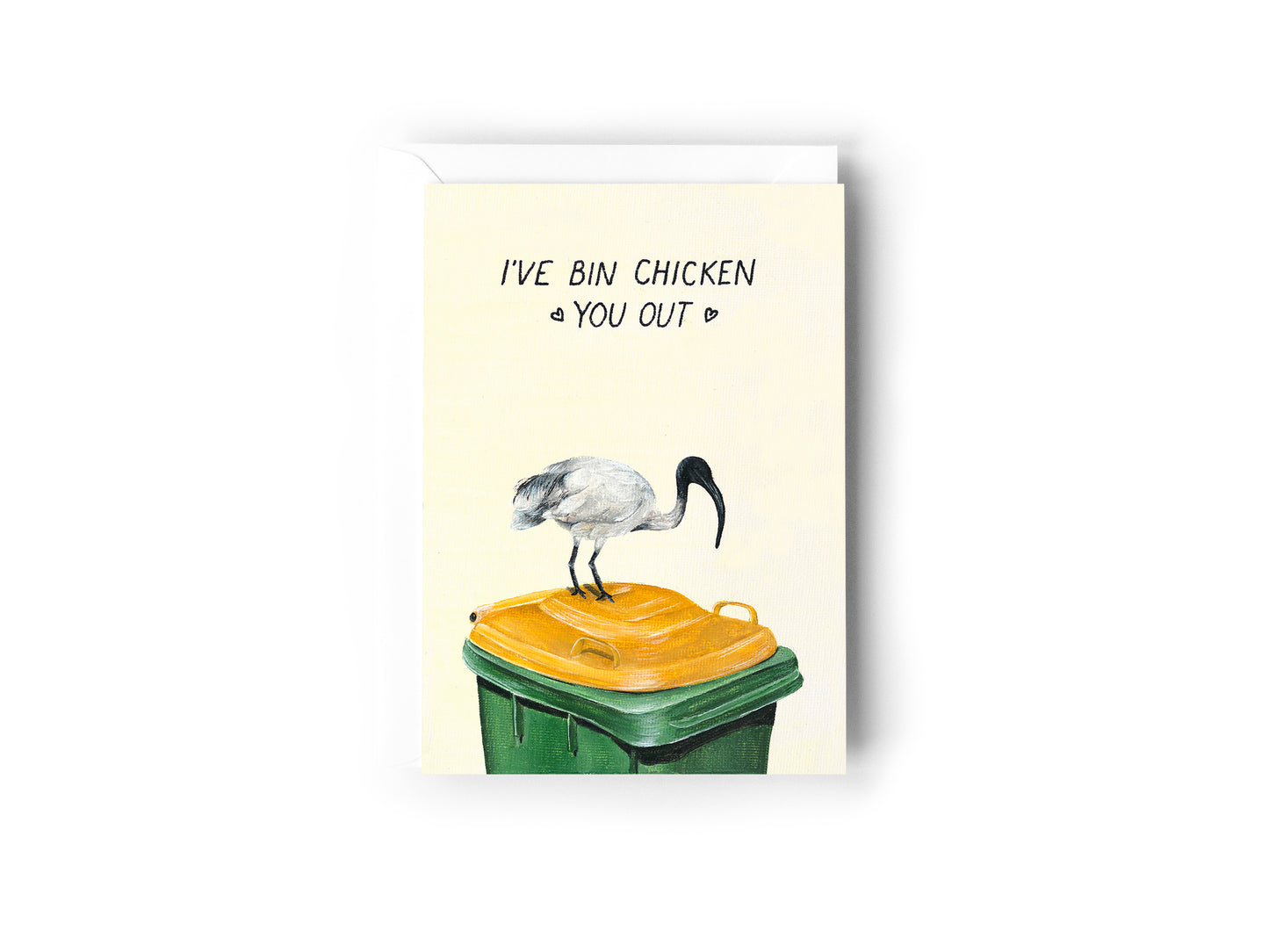 A greeting card design hand painted by Australian Artist Jessica Alpert with a bin chicken on a green and yellow garbage bin illustration entitled 'I've Bin Chicken You Out'. The card has a white envelope behind it and sits on a white background.